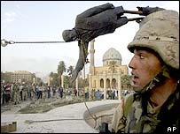 Iraqi civilians and US soldiers pull down a statue of Saddam Hussein, Baghdad, 9 April 2003 